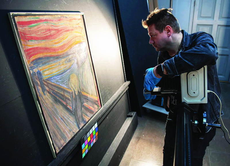 In this undated handout image, a curator at the National Museum of Norway uses an infrared scanner in the quest to reveal author of hidden graffiti on Edvard Munch's original painting of The Scream in Oslo.-AFP 