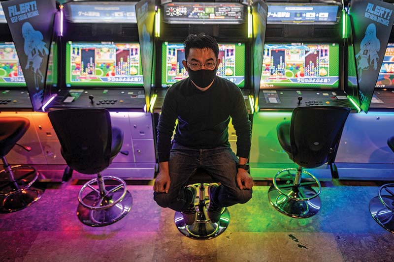 This picture shows Yasushi Fukamachi, a manager at the Mikado game center, posing in front of arcade game machines following an interview with AFP in the Shinjuku district of Tokyo.-AFP photosn