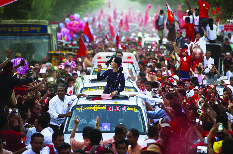YANGON: This file photo taken on November 1, 2015 shows Myanmar opposition leader Aung San Suu Kyi gesturing towards supporters as she travels in a motorcade ahead of a campaign rally for the National League for Democracy in Yangon.-AFPn