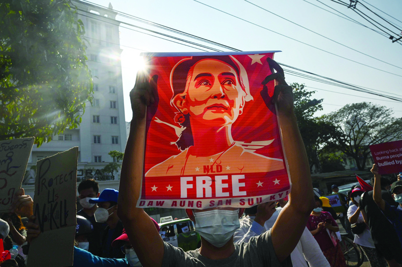 YANGON: A protester holds up a poster featuring Aung San Suu Kyi during a demonstration against the military coup at in front of the Central Bank of Myanmar in Yangon yesterday.-AFP n
