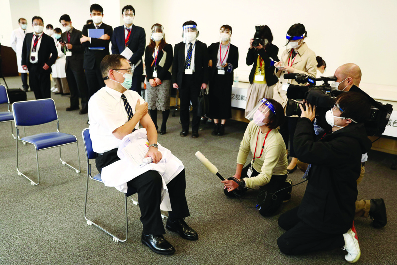 TOKYO: Director of the Tokyo Medical Center Kazuhiro Araki (left) speaks to the media after receiving a dose of the COVID-19 vaccine as the country launches its inoculation campaign in Tokyo yesterday.-AFP n