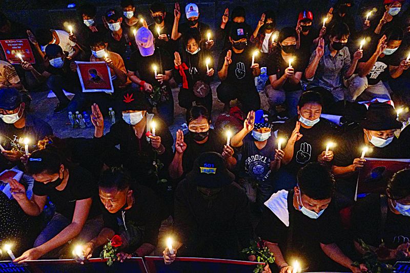 YANGON: Protesters hold a candlelight vigil outside the US Embassy during a demonstration against the military coup in Yangon yesterday.-AFP n