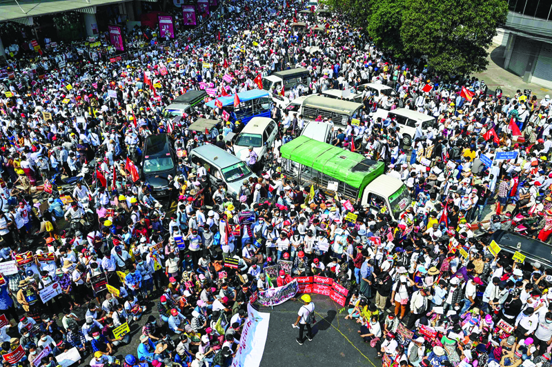 YANGON: Protesters mass around vehicles as they block roads during a demonstration against the military coup in Yangon yesterday.-AFP n