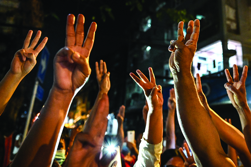 YANGON: People give a three-finger salute after calls for protest went out on social media in Yangon yesterday as Myanmar's ousted leader Aung San Suu Kyi was formally charged on Wednesday two days after she was detained in a military coup. -- AFPn
