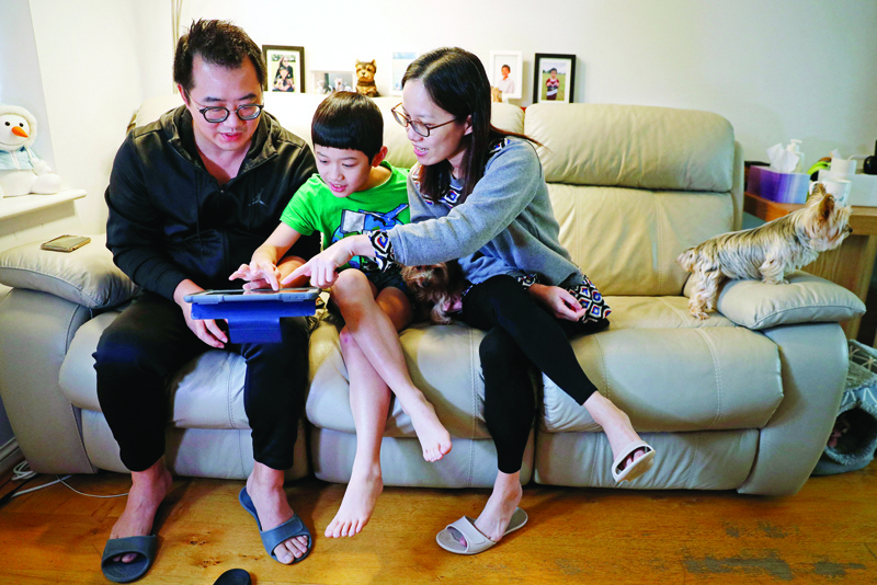 LONDON: This photo taken on January 26, 2021 shows Winston Wong (left), who arrived in Britain last year from Hong Kong, and his wife Connie Chan (right) with their son Cheston at home in Chelmsford.- AFPn