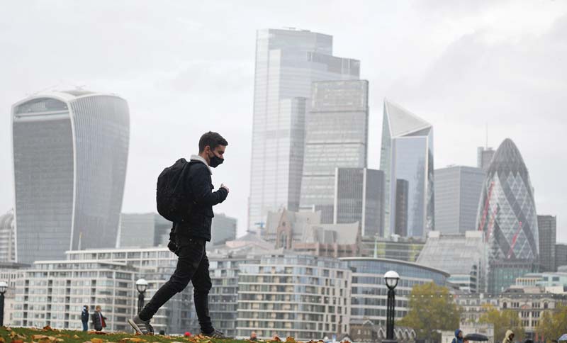 LONDON: In this file photo, a man walks along the southern bank of the River Thames with the office towers of the City of London in the background in London.  London's powerful financial services sector are losing market share in derivatives and equity brokerage to competition from Amsterdam in Europe and the United States, just over a month after Brexit came into force. - AFPnn