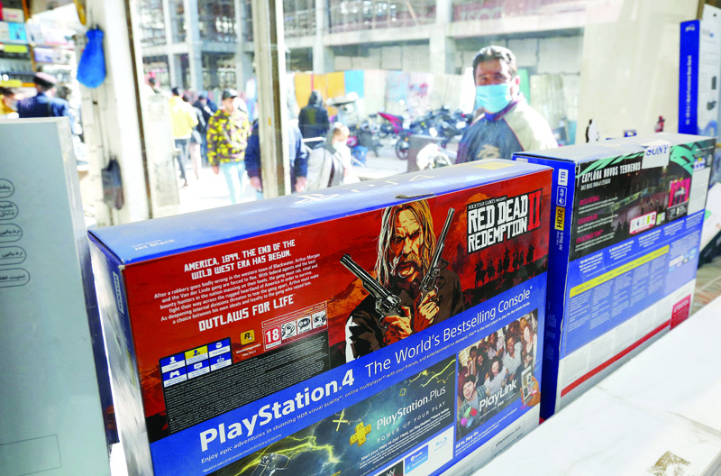 TEHRAN: A man walks past a window shop displaying PlayStation 4 (PS4) game consoles for sale at a shop in the central market of Iran's capital Tehran. Prices of popular gadgets such as PlayStations and iPhones could rise because of microchip shortages, experts warned yesterday.-AFPn