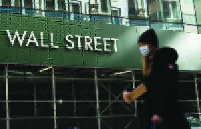 A woman walks on Wall Street in New York. - AFPn