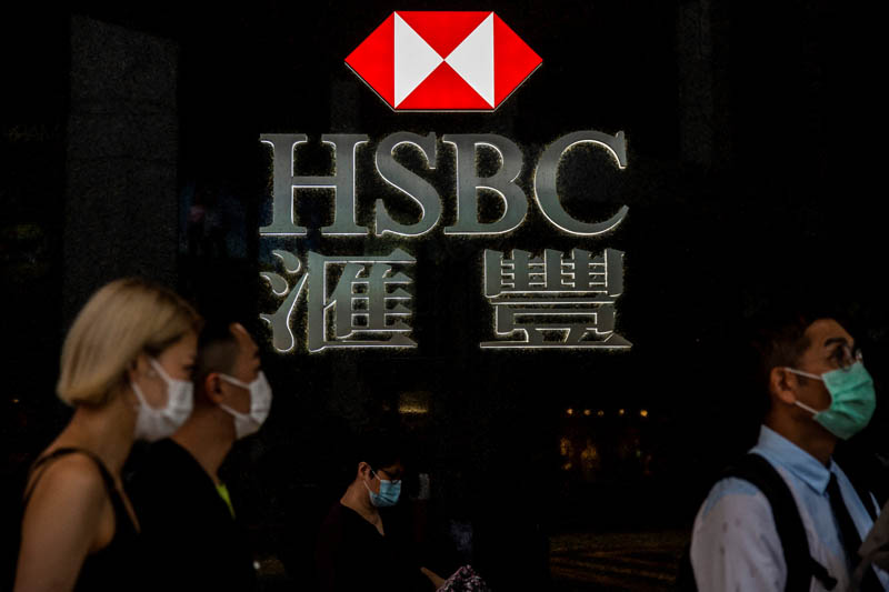 Pedestrians walking past the logo for HSBC in Hong Kong. – AFPn