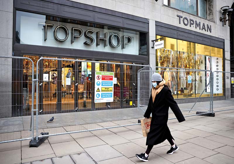 LONDON: A pedestrian passes a closed branch of the fashion retailer Topshop in central London yesterday. - AFPn