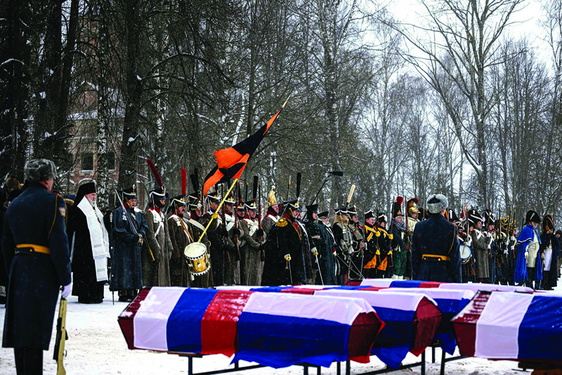 VIAZMA, Russie: Re-enactors in period uniforms stand next to coffins containing remains of Russian and French soldiers during a burial ceremony in the western town of Vyazma yesterday.-AFP n