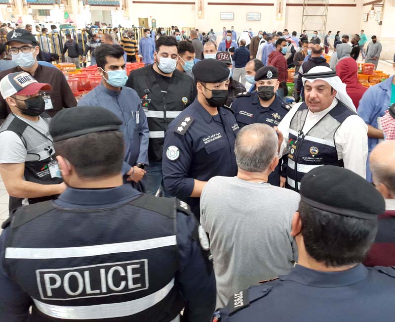 KUWAIT: Commerce ministry officials, supported by the police, stop fish auctions at the Souq Sharq fish market yesterday. - Photo by Fouad Al-Shaikh n