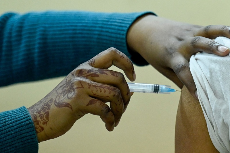 NEW DELHI: A medical worker inoculates a sanitation worker of Municipal Corporation of Delhi (MCD) with a COVID-19 vaccine at a vaccination center yesterday. – AFP n