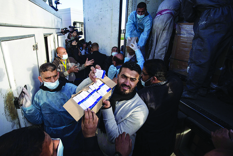 GAZA: Workers unload boxes of Russian-made Sputnik V vaccine doses from the UAE from a truck upon its arrival in the Gaza Strip via the Rafah crossing with Egypt yesterday. - AFP n