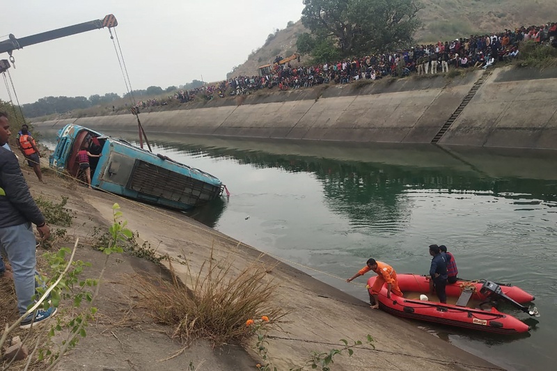 Onlookers stand along a canal as rescue teams search for survivors after a bus plunged into a canal killing at least 39 passengers in Sidhi district of Madhya Pradesh state yesterday. – AFP n
