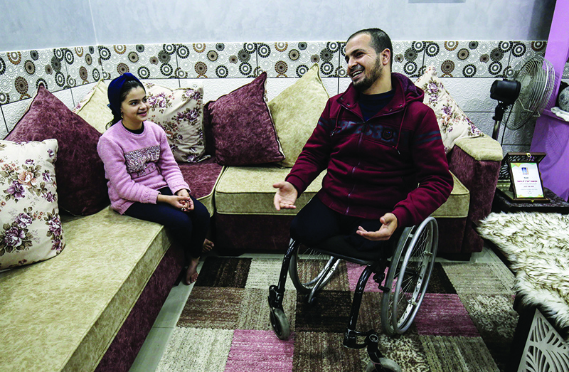 GAZA: Muhammad Abu Jazar, who lost his legs in an Israeli raid which claimed the lives of his wife and two of his children, is seen with his daughter Maisam at their home in Rafah on Feb 6, 2021. - AFP nn