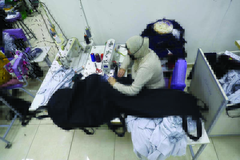 SIDON: A woman sews a body bag for COVID-19 victims at a factory on Tuesday. – AFP n