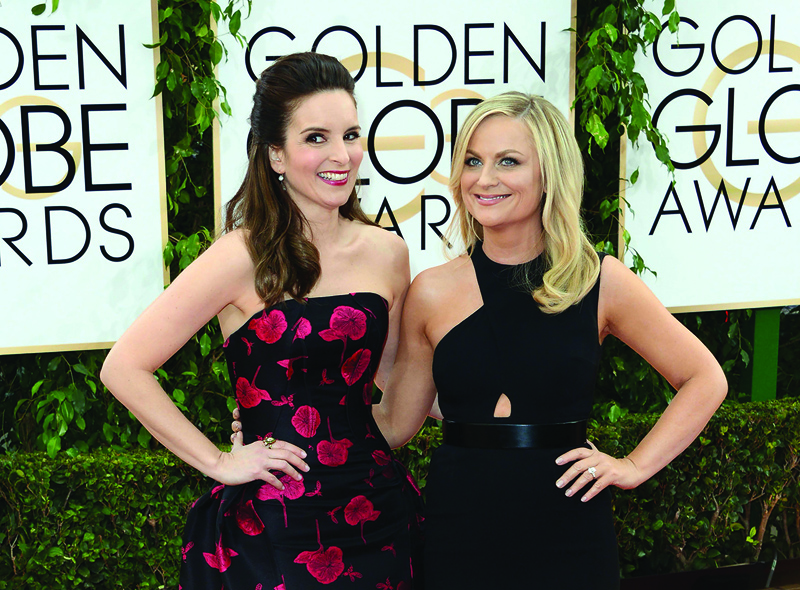 This file photo shows actress Tina Fey (left) and Amy Poehler (right) arriving for the 71st Golden Globe Awards held at the Beverly Hilton hotel in Beverly Hills. -AFP photosn