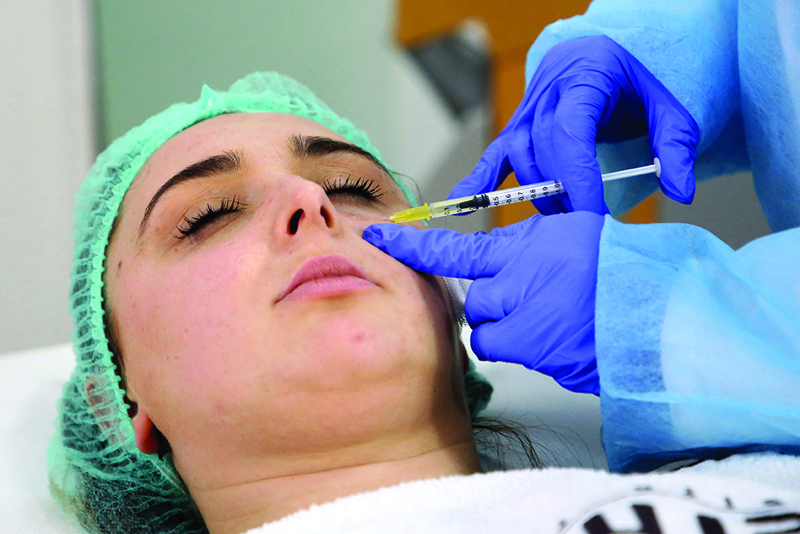 Dermatologist Brunilda Bardhi applies esthetic treatment to a woman at a clinic in Tirana.