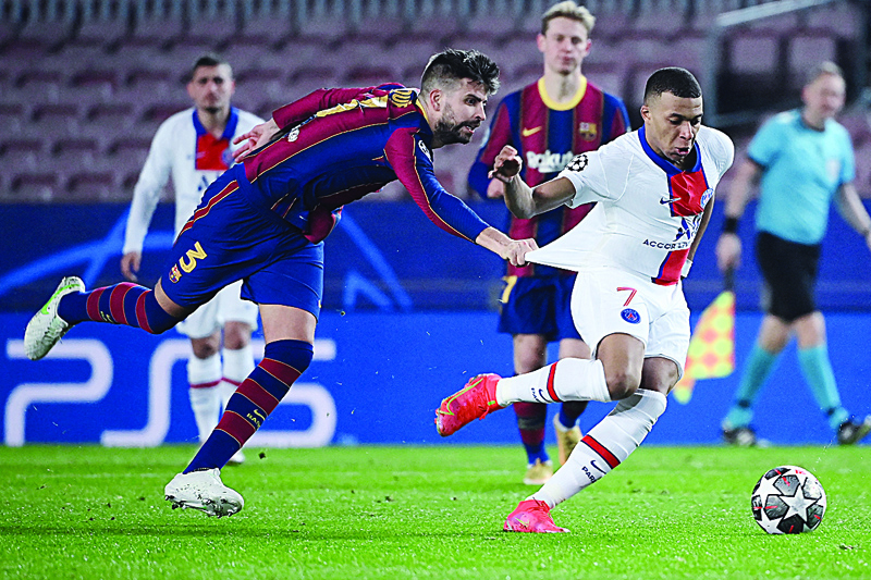 BARCELONA: Barcelona's Spanish defender Gerard Pique (left) challenges Paris Saint-Germain's French forward Kylian Mbappe during the UEFA Champions League round of 16 first leg football match between FC Barcelona and Paris Saint-Germain FC at the Camp Nou stadium in Barcelona on Tuesday. - AFPn