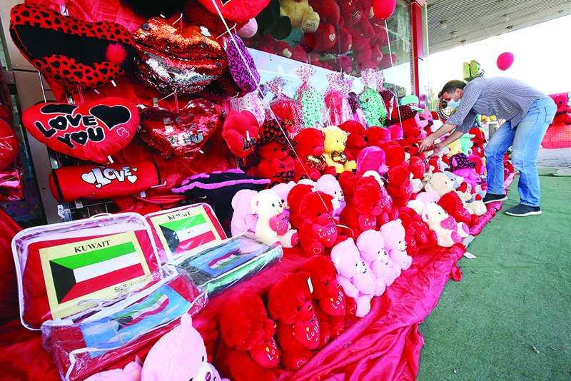 A vendor arranges teddy bears outside a shop in Kuwait city yesterday, as he waits for customers on Valentine's Day.