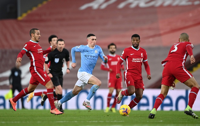 LIVERPOOL: Manchester City's English midfielder Phil Foden (center) runs through the Liverpool defense at Anfield yesterday. - AFP n