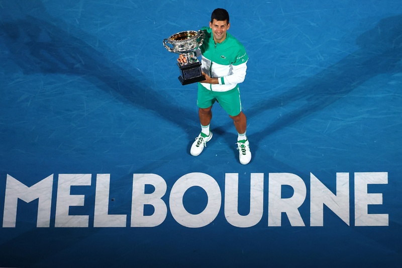 MELBOURNE: Serbia's Novak Djokovic holds the Norman Brookes Challenge Cup trophy after beating Russia's Daniil Medvedev to win their men's singles final match on day fourteen of the Australian Open tennis tournament in Melbourne yesterday. - AFP n