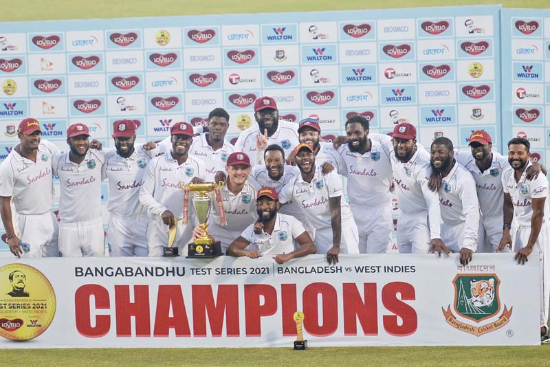 DHAKA: West Indies' players pose with the Test tournament trophy after winning the second Test cricket match against Bangladesh at the Sher-e-Bangla National Cricket Stadium in Dhaka yesterday. - AFPn