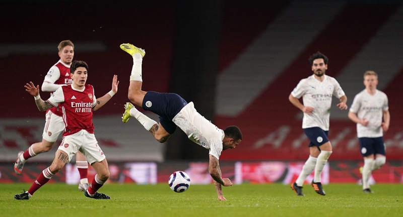 LONDON: Manchester City's Brazilian striker Gabriel Jesus is felled by Arsenal's Spanish defender Hector Bellerin (left) during an English Premier League match at the Emirates Stadium yesterday. – AFP n