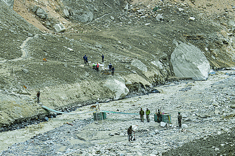 Army soldiers build a temporary bridge for residents near Raini village of Chamoli district following a flash flood thought to have been caused when a glacier broke off on February 7. - AFPn
