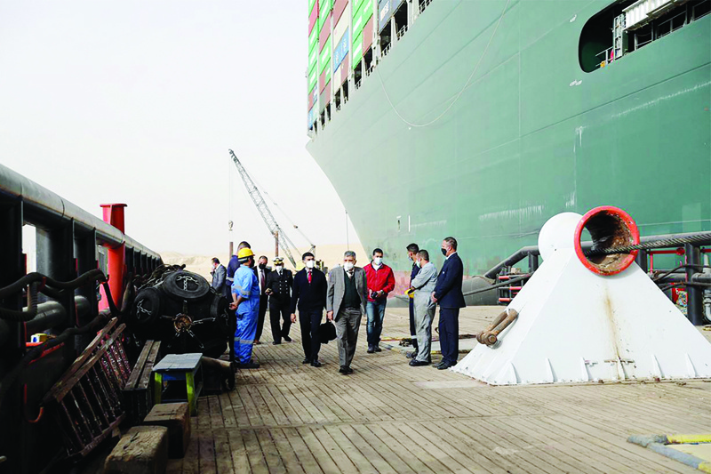 Egyptian officials checking the operation trying to free Taiwan-owned cargo MV Ever Given (Evergreen), a 400-metre- (1,300-foot-) long and 59-metre wide vessel, lodged sideways and impeding all traffic across the waterway of Egypt's Suez Canal yesterday. - AFPn
