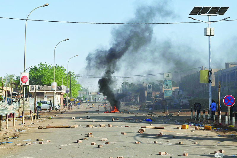 NIAMEY: Picture shows a fire in a street and projectiles on the ground as Niger's opposition supporters protest after the announcement of the results of the country's presidential run-off in Niamey. -AFP n