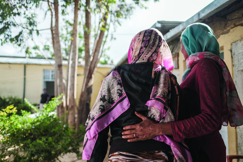 MEKELE: Eyerusalem (left), 40, is held by an assistant at a safe house for survivors of sexual assault, in Mekele. She was raped in a village outside of Adigrat by Eritrean soldiers. - AFPn