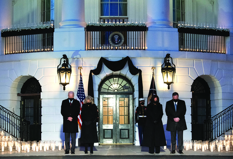 WASHINGTON, DC:  In this file photo taken on February 22, 2021 US President Joe Biden, First Lady Jill Biden, US Vice President Kamala Harris and her husband, Doug Emhoff, hold a moment of silence during a candelight ceremony in honor of those who lost their lives to Coronavirus on the South Lawn of the White House in Washington, DC. - AFPn