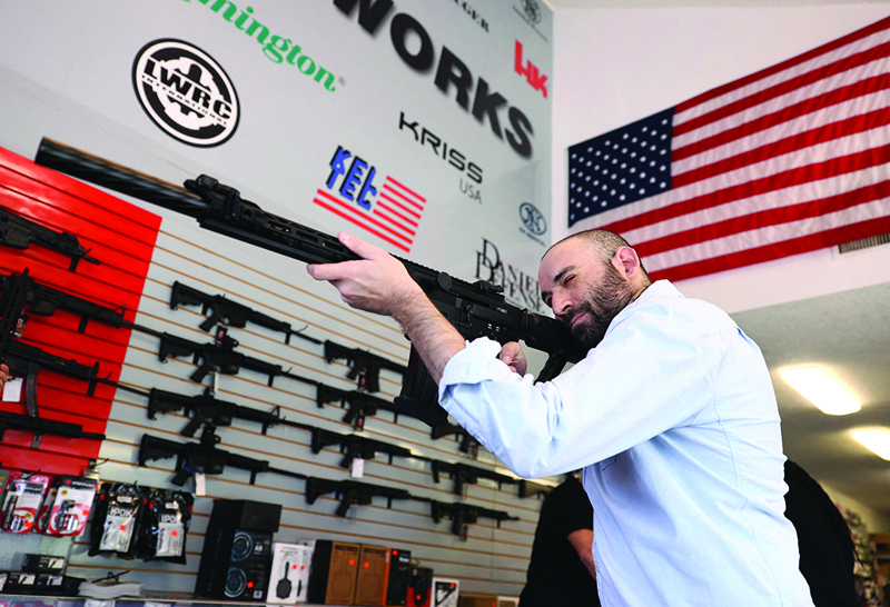 DELRAY BEACH, Florida: Austin Title handles a weapon as he visits WEX Gunworks on Wednesday in Delray Beach, Florida. - AFPn