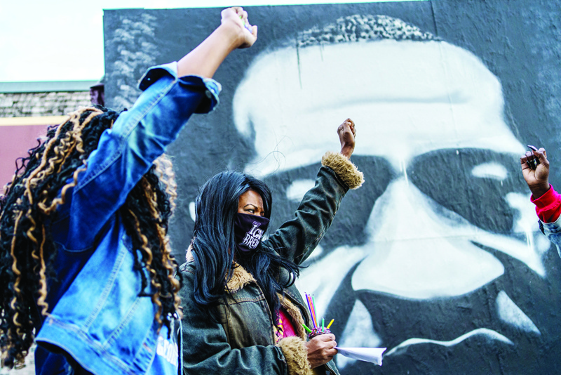 In this file photo taken on October 14, 2020 Paris Stevens (left) and Angela Harrelson (right), George Floyd's cousin and aunt, hold their fists as people gather in celebration of George Floyd's 47th birthday in Minneapolis, Minnesota. - AFPn