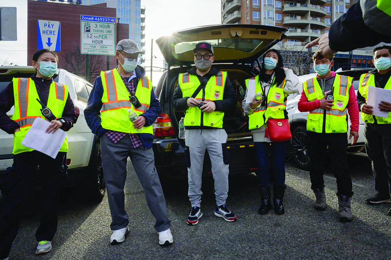NEW YORK: In this photo members of the Public Safety Patrol, a volunteer anti-hate crime group, prepare for a patrol in a car park in the Flushing neighborhood of Queens, New York. — AFP