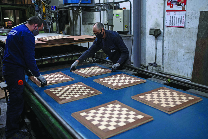 Employees of Rechapados Ferrer make chessboards in La Garriga near Barcelona.-AFP n