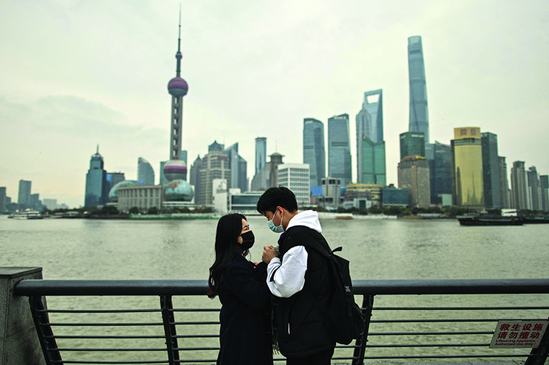 In this photo a couple visits the promenade on the Bund along Huangpu River in Shanghai. -AFP