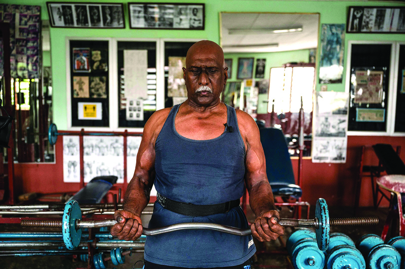 Bodybuilder A. Arokiasamy lifting a barbell at his gymnasium. - AFP photos