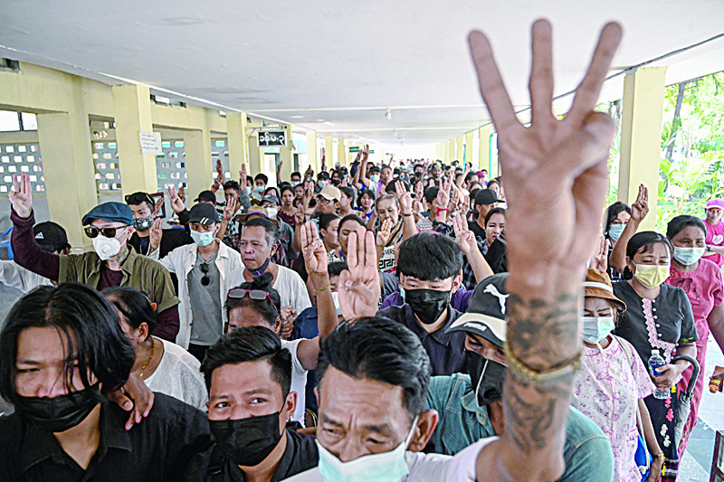 YANGON: Mourners hold up the three finger salute during the funeral of teenage protester Aung Kaung Htet in Yangon yesterday a day after he was killed by security forces at a demonstration against the military coup.-AFP n