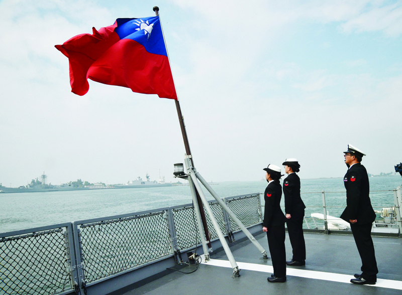 Taiwanese sailors salute the island's flag on the deck of the Panshih supply ship after taking part in annual drills, at the Tsoying naval base in Kaohsiung in this file photo.-AFPn