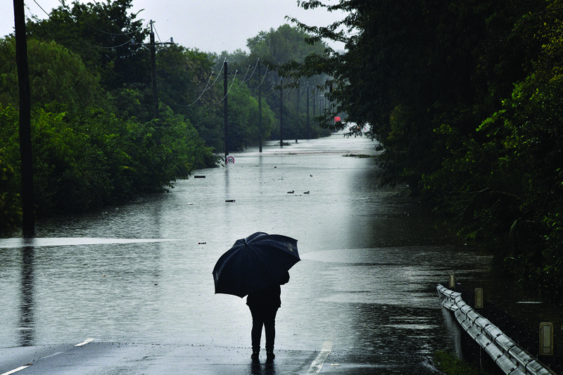 SYDNEY: A man looks at a road inundated by floodwaters in Richmond suburb yesterday as Sydney braced for its worst flooding in decades after record rainfall caused its largest dam to overflow and as deluges prompted mandatory mass evacuation orders along Australia's east coast. - AFPn