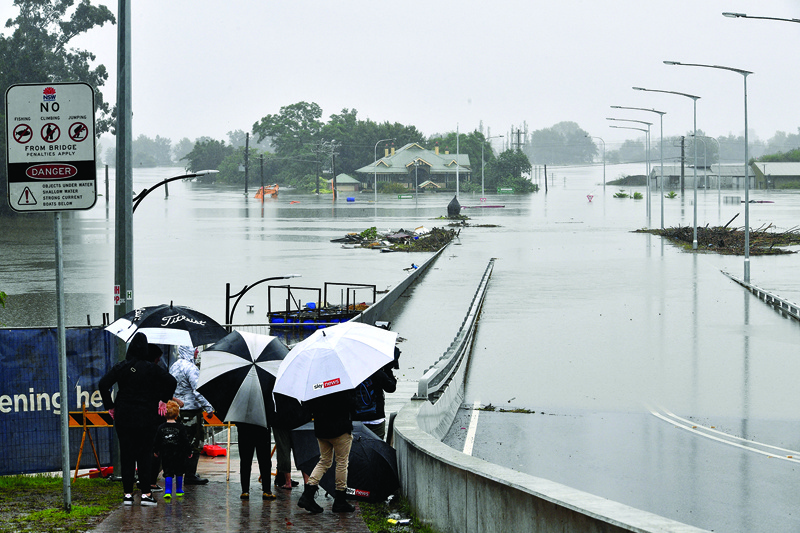 SYDNEY: Residents look out at a flooded residential area in the Windsor area in northwestern Sydney yesterday after torrential downpours have lashed Australia's southeast for days. - AFPn