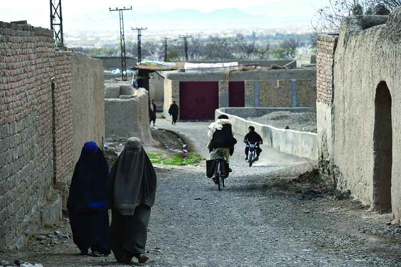 Women wearing burqas walk along a road in the Arghandab district of Kandahar province. The Taleban are increasingly cutting off rural Afghan women from aid and strong-arming NGOs to follow their harsh edicts, spurring fears women will again bear the brunt of the insurgents' growing influence. - AFPnn