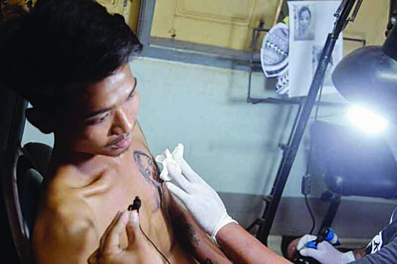 NAYPYIDAW, Myanmar: Photo shows 21-year-old Hein Yar Zar getting a tattoo of his late girlfriend Mya Thwate Thwate Khaing on his chest.-AFPn