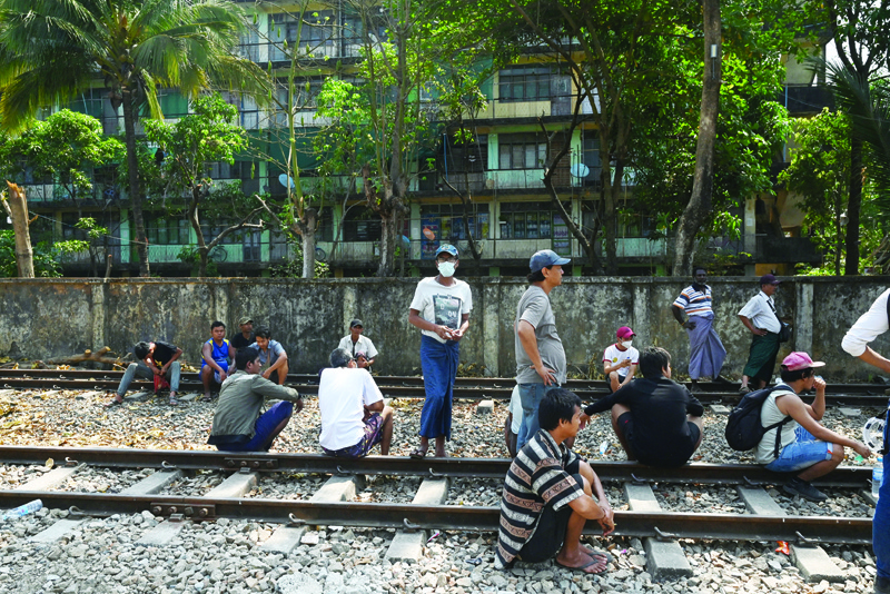 YANGON: Railway staff gather by the train tracks as security forces arrived at the Mahlwagone Railway Station to arrest workers involved in the Civil Disobedience Movement (CDM), in protest over the military coup, in Yangon yesterday.-AFPn
