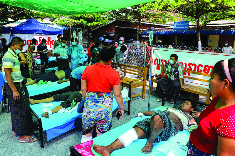YANGON: Protesters, who were shot with live rounds during a demonstration against the military coup, receive medical attention at a makeshift medical center in Mandalay yesterday.-AFPn