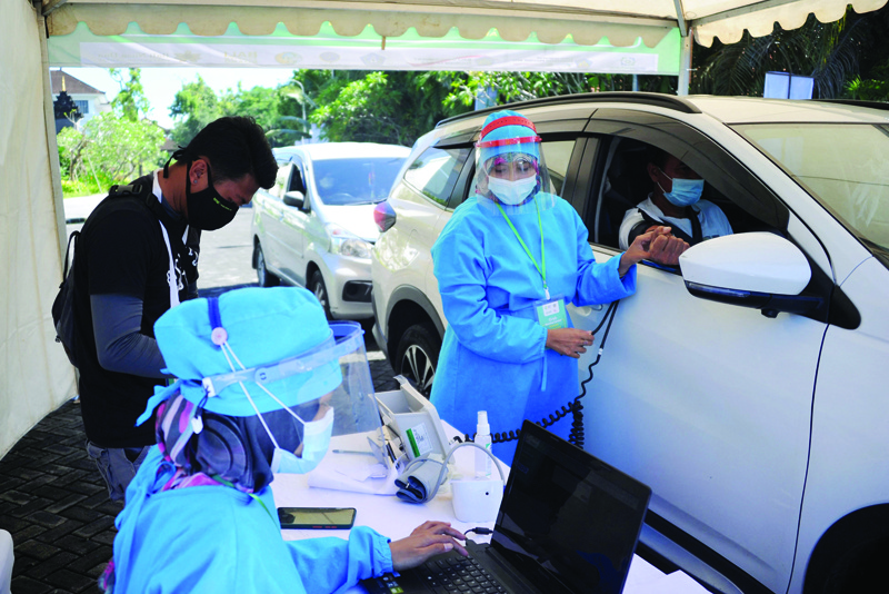 BALI, Indonesia: Medical workers prepare to administer the COVID-19 coronavirus vaccine during a drive-through vaccination service in Nusa Dua, Indonesia's resort island of Bali yesterday.-AFP n