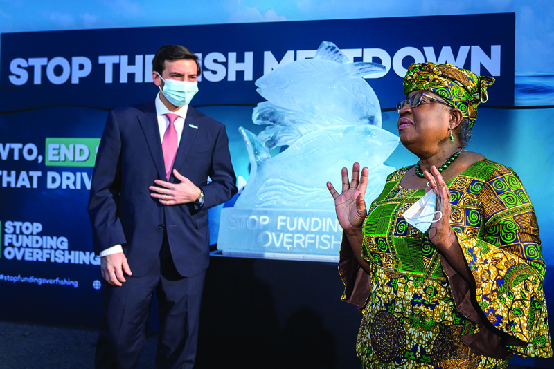 GENEVA: World Trade Organization (WTO) Director-General Ngozi Okonjo-Iweala (right) gestures with Chair of the fisheries subsidies negotiations at the WTO Colombian Ambassador Santiago Wills next to an ice sculpture depicting fish during an event by NGOs requesting urgent action to finalize the WTO agreement on ending subsidies that drive overfishing, yesterday in Geneva. - AGPn
